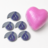 3D printed shrink wrap openers next to a wrapped heart bath bomb