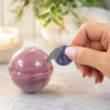 Serene Flame shrink wrap opener being used on a wrapped bath bomb