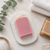 White soap saver mat with pink handmade soap in a spa flat lay