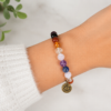Chakra intention bracelet with brass charm worn on the wrist